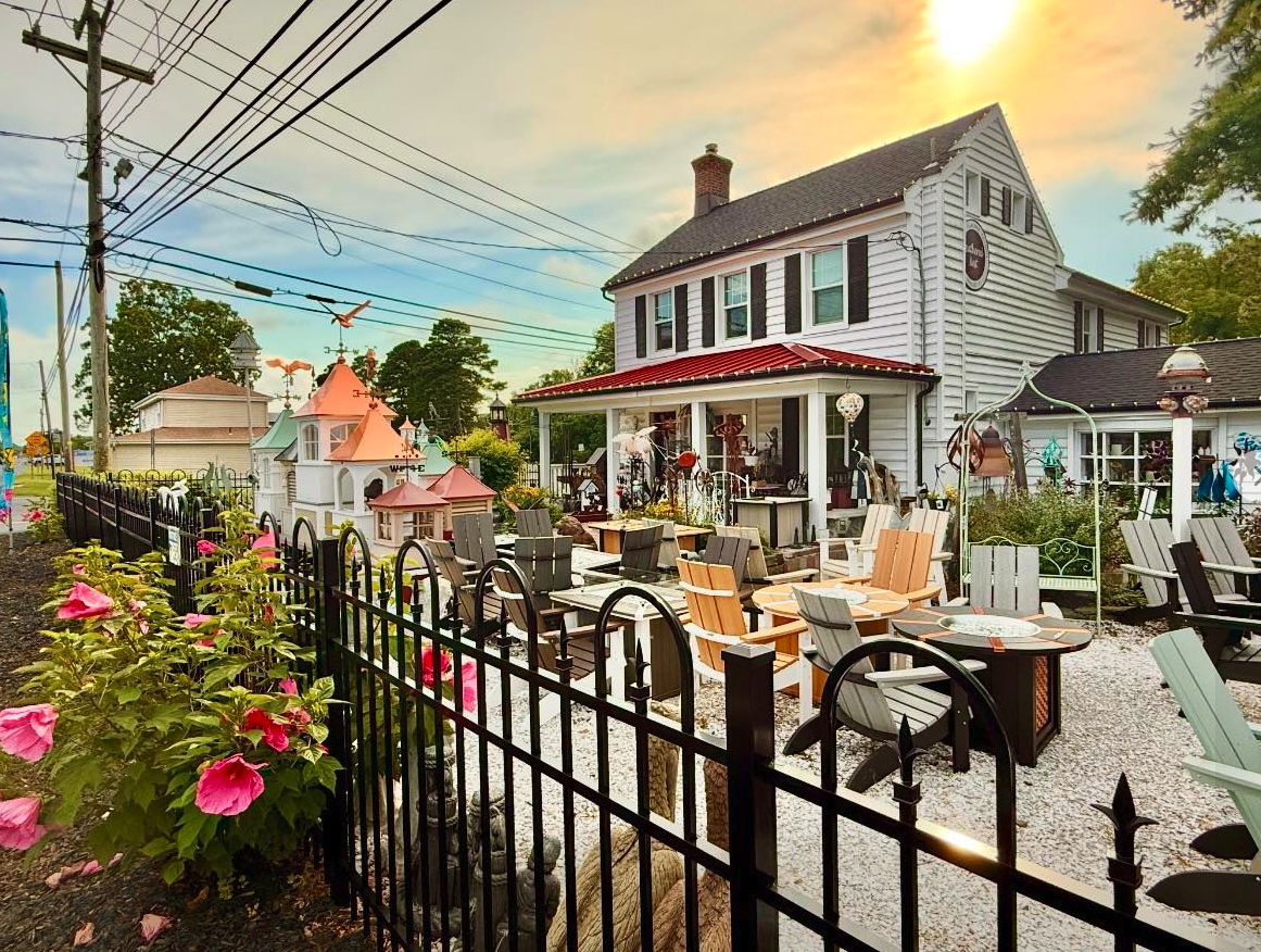 Feathered Nest storefront at golden hour with outdoor seating, cupolas and garden beds